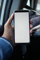 hand met slimme telefoon met leeg scherm in een auto foto