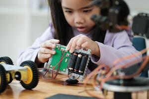 stam onderwijs concept. Aziatisch jong meisje aan het leren robot ontwerp. foto