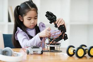 stam onderwijs concept. Aziatisch jong meisje aan het leren robot ontwerp. foto