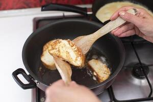 bakken wit brood croutons in een frituren pan. koken ontbijt. foto