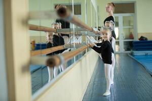 weinig meisjes Bij de ballet machine. les choreografie. jong ballerina's.. opleiding van de eerste groep Aan gymnastiek.acrobatiek les foto