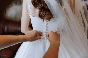 detailopname van vrouw handen aanraken jurk. vrouwen manicuren. een luxueus bruiloft ring Aan een vrouw vinger. foto