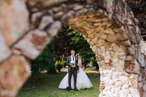 de bruid is gekleed in een elegant weelderig wit bruiloft jurk met een lang sluier en is klaar voor haar bruidegom. de eerste vergadering van de bruid en bruidegom foto