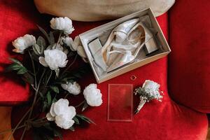 bruid verloving ring, stiletto's, parfum. bruiloft details van de bruid. bloemen mooi licht. bruiloft jurk foto