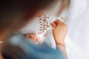 detailopname van vrouw handen aanraken jurk. vrouwen manicuren. een luxueus bruiloft ring Aan een vrouw vinger. foto