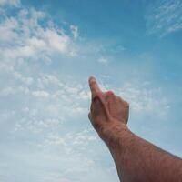 Mens hand- gebaren Aan de blauw lucht foto