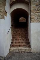 een boog met trap in de muur van een steen huis foto