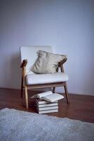 een ideaal plaats voor lezing en ontspannend, een wit fauteuil omringd door boeken in een helder kamer foto