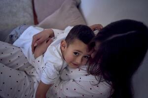 tiener- meisje en haar weinig broer zijn spelen en knuffelen in een hoofdkussen fort foto