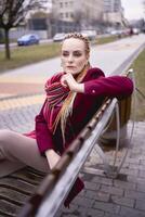 portret van een elegant middelbare leeftijd vrouw met vlechtjes Aan een voorjaar straat foto