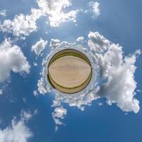 gemakkelijk groen klein planeet zonder gebouwen in blauw lucht met mooi wolken. transformatie van bolvormig panorama 360 graden. bolvormig abstract antenne visie. kromming van ruimte. foto