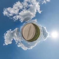 gemakkelijk groen klein planeet zonder gebouwen in blauw lucht met mooi wolken. transformatie van bolvormig panorama 360 graden. bolvormig abstract antenne visie. kromming van ruimte. foto