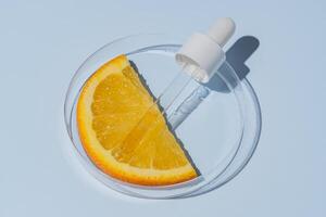 citrus laboratorium Onderzoek. schoonheidsmiddelen producties, aha componenten extractie. huid zorg schoonheidsspecialiste testen. Petri schotel met oranje fruit plak en pipet foto