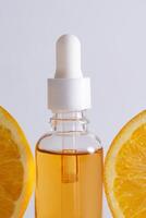 natuurlijk vitamine c serum, huidverzorging, essentieel olie producten. fles van vitamine c serum met vers sappig oranje fruit. schoonheid Product branding maquette. foto