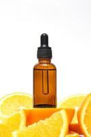 vitamine c serum in een amber fles met een pipet Aan een achtergrond van oranje citrus vruchten. citrus essentieel olie, aromatherapie cosmetica. biologisch spa schoonheidsmiddelen met kruiden ingrediënten foto
