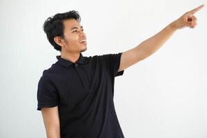 jong Aziatisch Mens glimlachen zelfverzekerd met hand- richten naar de links kant vervelend zwart polo t overhemd geïsoleerd wit achtergrond foto