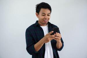 glimlachen of gelukkig gezicht jong Aziatisch Mens terwijl gebruik makend van mobiel telefoon geïsoleerd wit achtergrond foto