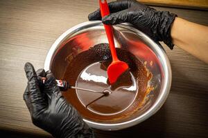 vrouw Koken smakelijk gesmolten chocola Aan tafel in keuken. foto