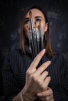 portret van een vrouw artiest, met borstels in haar handen. foto