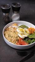 een bord met couscous, eieren, groenten en vlees Aan donker achtergrond hoek visie foto