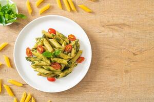 penne pasta met pestosaus en tomaten foto