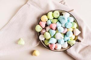 dichtbij omhoog van veelkleurig mini schuimgebakjes Aan een bord Aan de tafel top visie foto