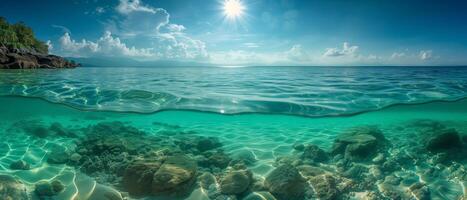 ai gegenereerd panorama visie van onderwater- zand en zee rotsen met zonnig blauw lucht en wolk, spleet visie voor de helft over- en onder water oppervlak, grote Oceaan oceaan foto