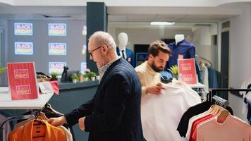 verschillend mensen boodschappen doen in kleinhandel op te slaan, op zoek voor rood zwart vrijdag korting etiketten Aan artikelen. klanten zoeken door hangers met kleding items in mode uitlaat, verkennen boetiek. foto