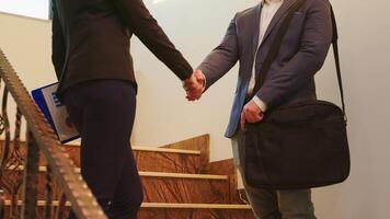 bedrijf vrouw en uitvoerend manager beven handen terwijl staand Aan trap bespreken in kantoor gebouw . groep van professioneel mensen uit het bedrijfsleven werken in modern financieel werkplek. foto