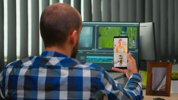 freelancer video editor met onbekwaamheid in rolstoel hebben video-oproep terwijl bewerken na-productie een project creëren inhoud in modern bedrijf kantoor. videograaf werken van foto studio