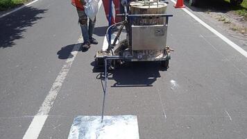 laag sectie van weg arbeider gebruik makend van thermoplastisch markering machine foto