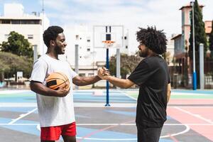 Afrikaanse Amerikaans vrienden spelen basketbal buitenshuis - stedelijk sport levensstijl concept foto