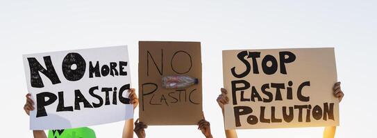 groep demonstranten protesteren tegen plastic verontreiniging en klimaat verandering - multiraciaal mensen vechten Aan weg Holding banners Aan omgevingen rampen - globaal opwarming concept foto