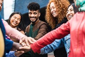 gelukkig multiraciaal vrienden hebben pret stapelen handen samen buitenshuis - jeugd mensen millennial generatie concept foto