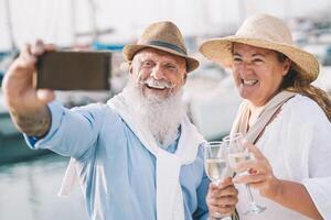 senioren paar nemen selfie met mobiel smartphone Aan zeilboot vakantie - gelukkig mensen hebben pret vieren drinken Champagne Aan boot reis - verhouding liefde en romantisch reizen dating concept foto