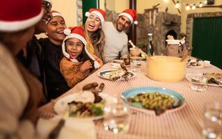 gelukkig Latijns familie hebben pret vieren Kerstmis vakantie terwijl dining samen Bij huis foto