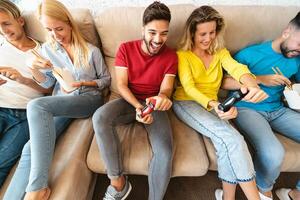 jong vrienden spelen online video spellen en aan het eten levering Aziatisch voedsel - millennial mensen hebben pret Aan nieuw technologie troosten - gaming vermaak en jeugd generatie levensstijl concept foto