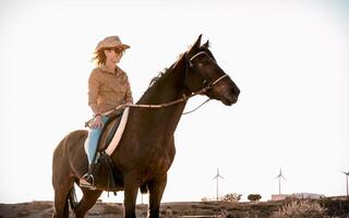 jong vrouw rijden een paard in corral boerderij foto