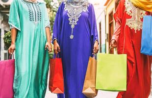 gelukkig moslim Dames aan het doen boodschappen doen in de stad centrum - Arabisch tiener meisjes hebben pret buying nieuw traditioneel Arabisch kleren in winkelcentrum - concept van mensen geloof, klant, consumentisme en verschillend cultuur foto