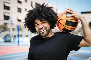 gelukkig afro Mens spelen basketbal buitenshuis - stedelijk sport levensstijl concept foto