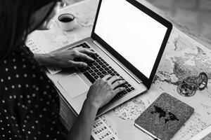 jong vrouw gebruik makend van laptop voor reservering vakanties - technologie en reizen concept foto