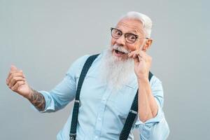 gelukkig modieus senior Mens hebben pret poseren in voorkant camera - mode baard volwassen mannetje genieten van gepensioneerd tijd - ouderen mensen levensstijl en hipster cultuur concept foto