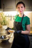 vrouw Koken smakelijk gesmolten chocola Aan tafel in keuken. foto