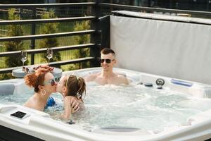 in zomer, de familie rust in de buitenshuis heet kuip foto