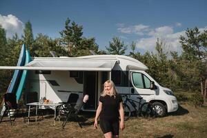 een gelukkig toerist in haar camper in natuur foto