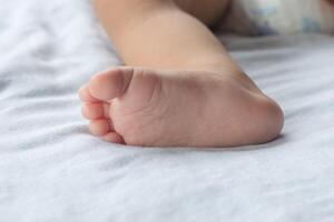 detailopname van zacht baby's voeten Aan matras. foto