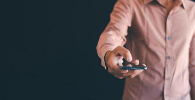 de man's hand- is gebruik makend van de mobiel telefoon foto