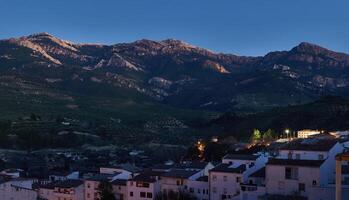 Sierra de Cazola. vraagbaak Andalusië Spanje. mooi bergen Bij avond en wit gebouwen Aan de voorgrond. foto