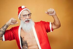 gelukkig senior Mens hebben pret vervelend Holding Kerstmis kleren - volwassen hipster vieren Kerstmis vakantie - ouderen modieus mensen en traditioneel levensstijl cultuur foto