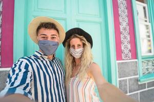 jong paar vervelend gezicht masker nemen selfie Aan vakantie - mensen hebben pret op reis opnieuw gedurende corona virus het uitbreken - liefde verhouding en toerisme concept foto